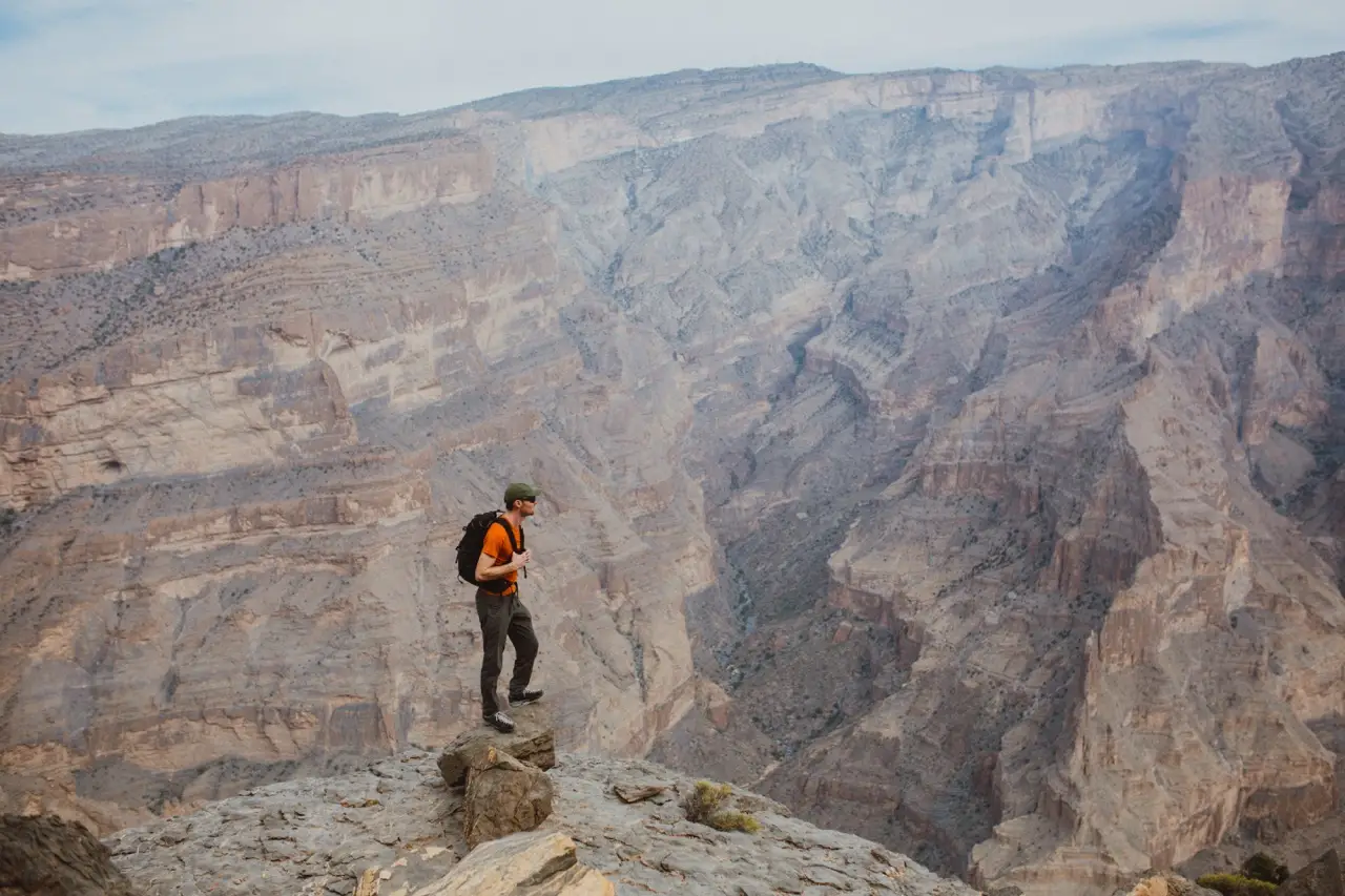 A hiker standing on the rim of a deep canyon.