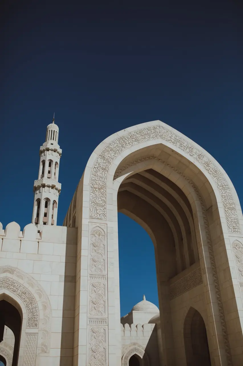 A carved marble arch and minaret at the Sultan Qaboos Grand Mosque in Muscat.