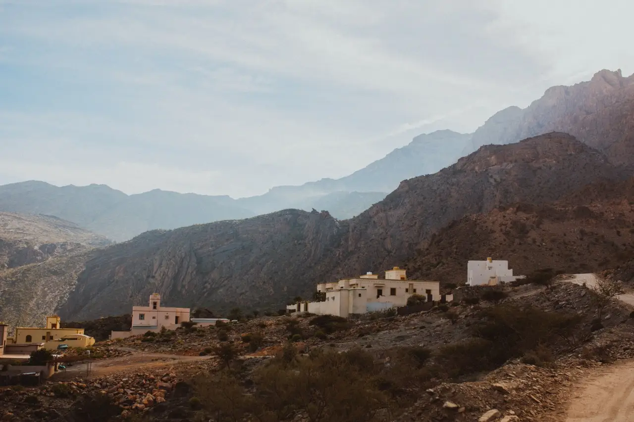 A small mountain village on a slope below high peaks.