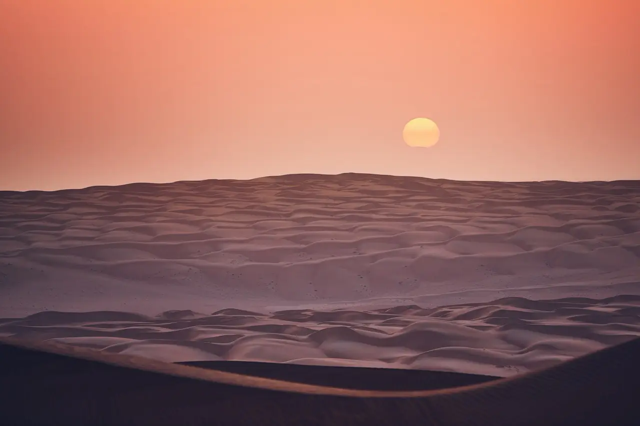 Sunrise over rolling dunes.