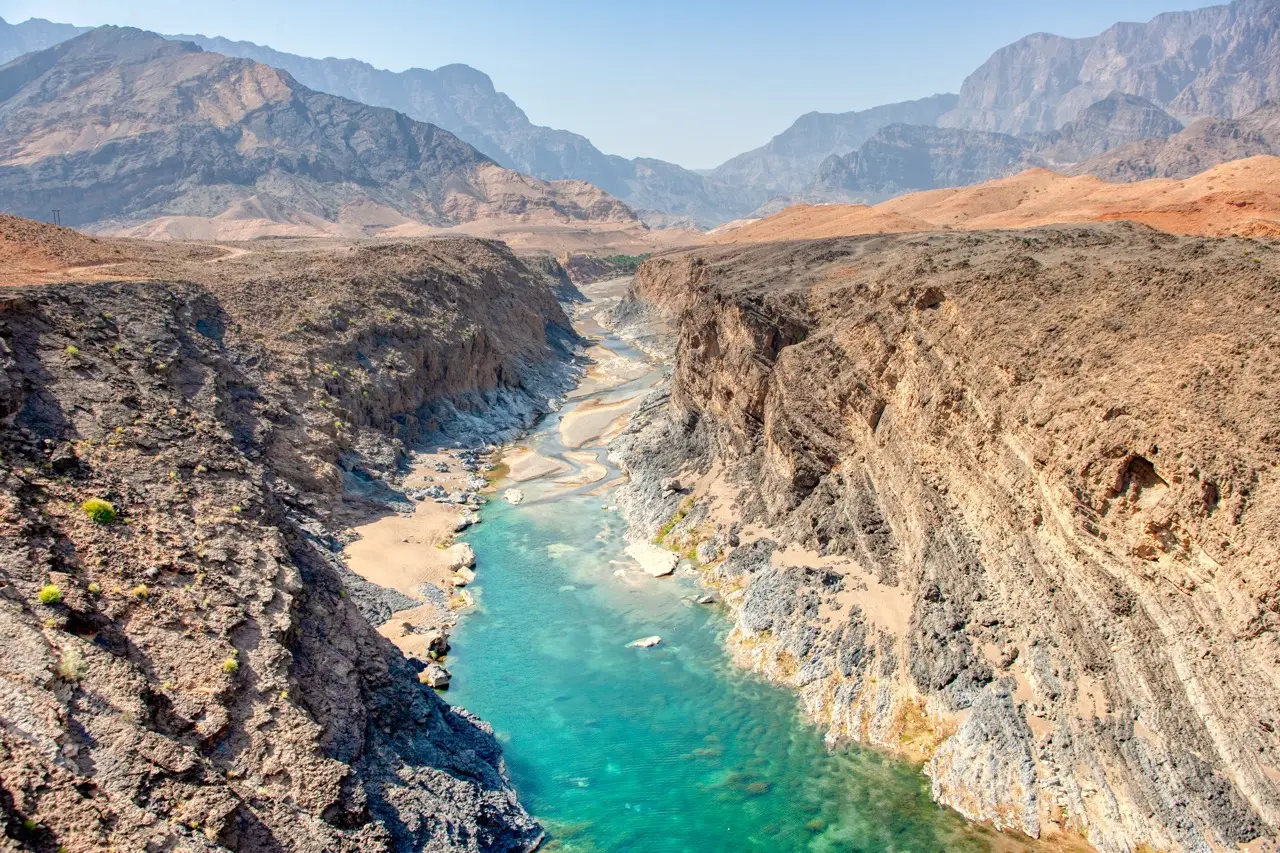 Wadi Dayqah: a turquoise river in a deep rocky gorge.